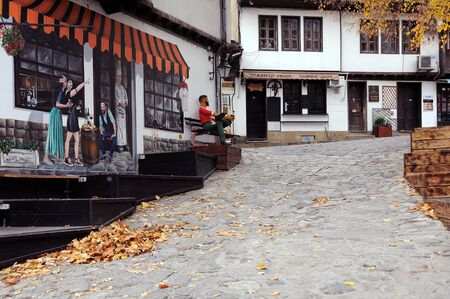 VELIKO TARNOVO, BULGARIA - NOVEMBER 11, 2019: Yellow fallen leaves in the empty lane of the town in the fallのeditorial素材