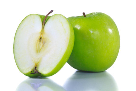 isolated cut green apple on choppong block on white with shadowの写真素材