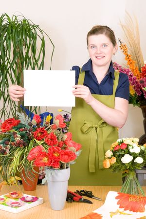 Young female florist holding white signの写真素材