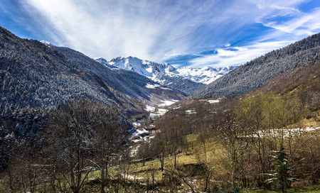 Valley between high snowy mountains and green pasturesの写真素材