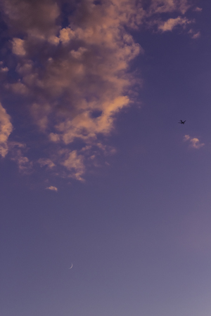 Plane flying over the sky at sunsetの写真素材