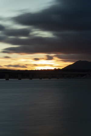 Nice sunset after a viaduct crossing over a lakeの写真素材