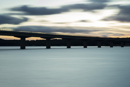Nice sunset after a viaduct crossing over a lakeの写真素材