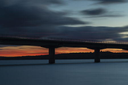 Nice sunset after a viaduct crossing over a lakeの写真素材