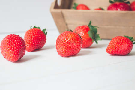 Horizontal close Up, fresh and organic strawberries in a rustic wooden box and on a white wooden background. Concepts, selective focus, copy spaceの写真素材