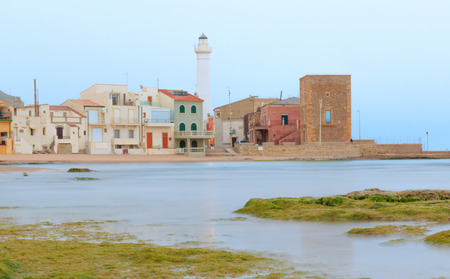 Daytime at Punta Secca Beach with the lighthouse and the watchtower,Torre Scalambri in Santa Croce Camerina, Sicily, Italyの写真素材