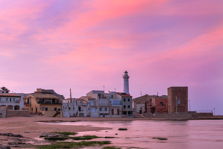 Sunrise at Punta Secca Beach with the lighthouse and the watchtower,Torre Scalambri in Santa Croce Camerina, Sicily, Italyの写真素材