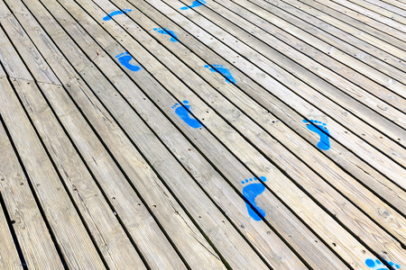 Blue painted footprints on wooden backgroundの写真素材
