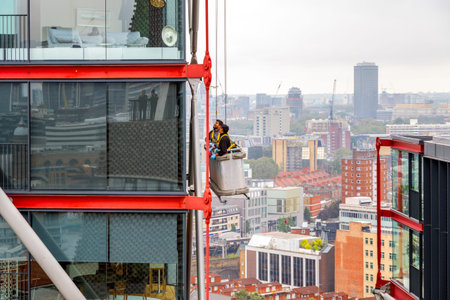 London, UK - September 20, 2016 - Window cleaners working on a high rise building with cityscape in the backgroundのeditorial素材