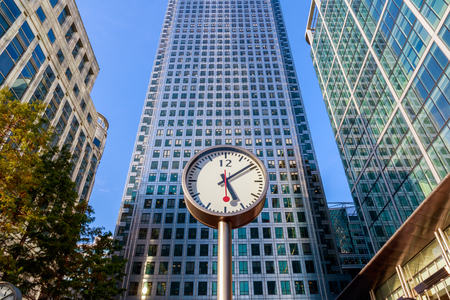 Clock and skyscrapers in Canary Wharf, financial district of Londonの写真素材