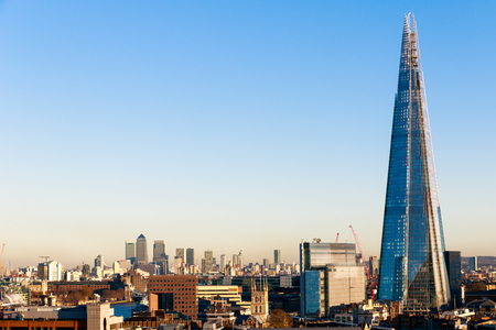 Financial district cityscape of London, including Canary Wharf and The Shard against a blue cloudless skyのeditorial素材