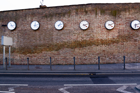 A series of clocks registering the times in major cities on Westferry Road, Londonの写真素材