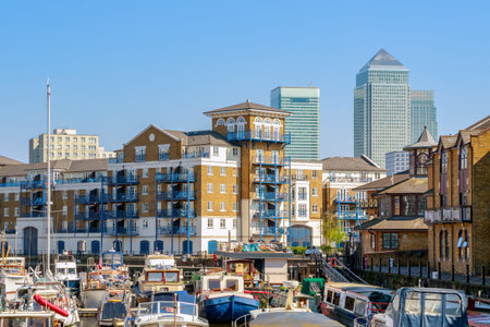 Boats and yachts moored at Limehouse Basin Marina in London with Canary Wharf in the background