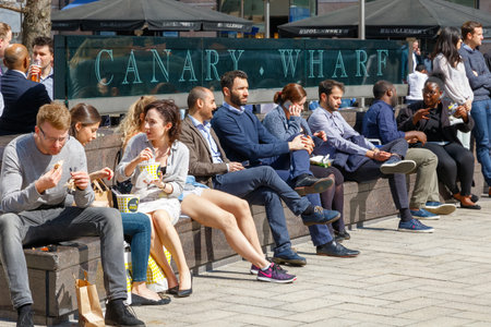 London, UK - May 10, 2017 - Outdoor space in Canary Wharf packed with people drinking, eating on...