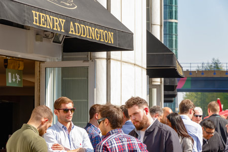 London, UK - May 10, 2017 - Dockside bar in Canary Wharf packed with people drinking on a sunny day...