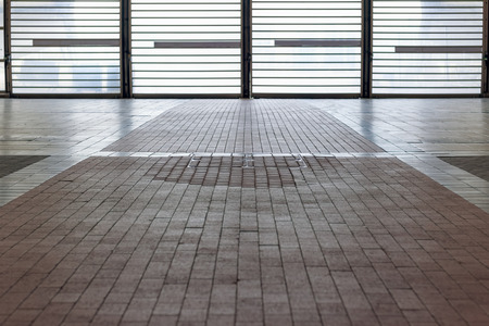 Tiled floor with backlit barred door for concept useの写真素材