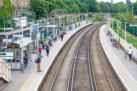 London, UK - May 23, 2017 - West Brompton overground station platforms, with commuters waiting on platformsのeditorial素材