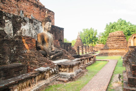 sitting Buddha sculpture among the ruins in Sukhothai historical park, Thailandの写真素材