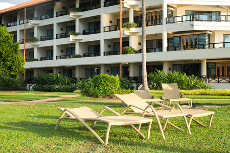 bleach chairs under the palm tree viewing the sunset on the seaのeditorial素材