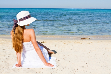 Young woman sitting on the beachの写真素材