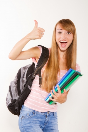 Smiling and emotional female student with books in hands isolated on whiteの写真素材
