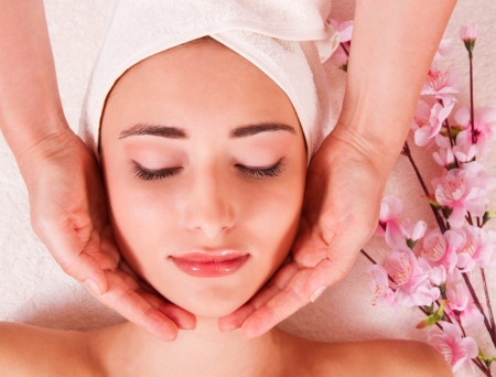 beautiful woman doing facial massage in a spaの写真素材