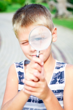inquisitive boy with a lens in the parkの写真素材