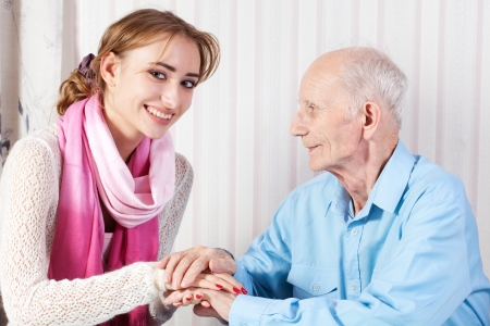 Senior man with her caregiver at home の写真素材