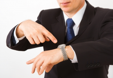 Businessman points at his watch  Close up on a white background の写真素材
