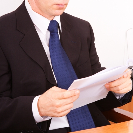 Businessman reading a letter. Close-up on a white background.の写真素材