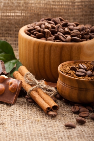 coffee beans in a wooden bowl on burlap backgroundの写真素材