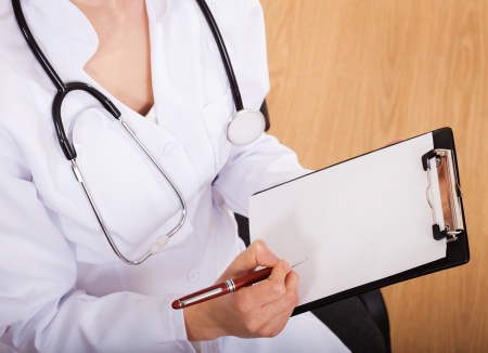 Female doctor showing blank clipboardの写真素材