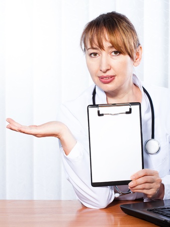 Female doctor showing blank clipboard の写真素材