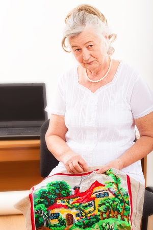 Portrait of an old woman engaged in needleworkの写真素材