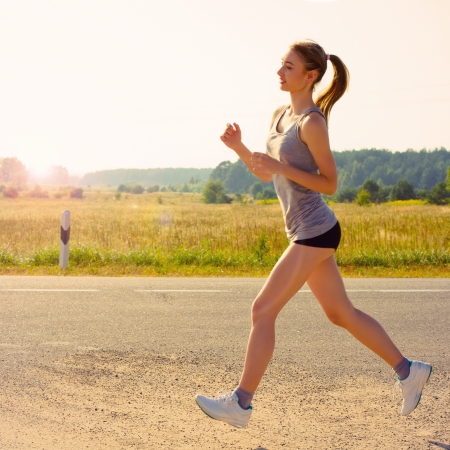 Portrait of  young woman jogging in nature. Close upの写真素材