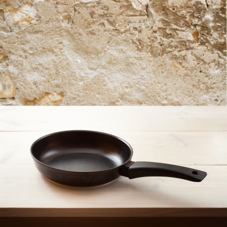 Empty frying pan on wooden background. Space for text, squareの写真素材