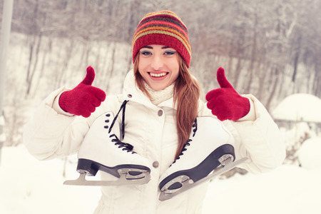 Beautiful young woman smiling happily. Winter activities at the rink with skatesの写真素材