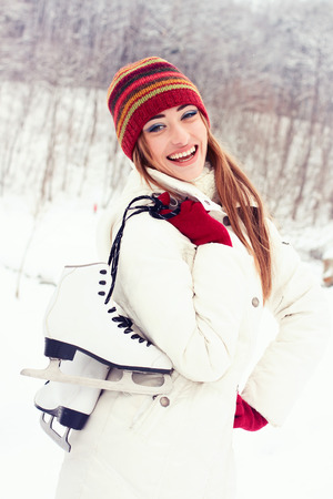 Beautiful young woman smiling happily. Winter activities at the rink with skatesの写真素材