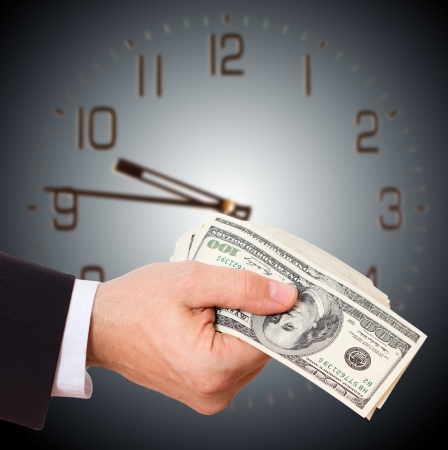 businessman holding cash dollars in  hands of passing them to the client. Concept of time is money. Isolated, space for textの写真素材