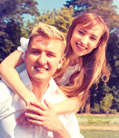 Portrait of Beautiful Young Couple in Love on nature. Man and Woman Smiling Charmingly. Young Couple Kissing Summer on Sunny Sky Backgroundの写真素材