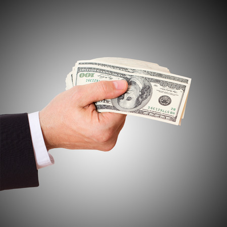 businessman giving cash dollars in  hands of passing them to the client. Concept of finance success. Isolated, space for textの写真素材