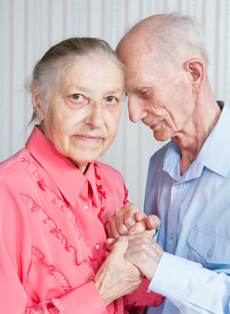 Closeup portrait of  smiling elderly couple Old people holding hands の写真素材