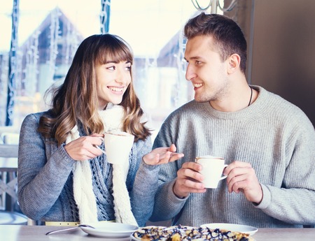 Portrait of Beautiful Young Couple in Love, couple having fun talking in cafe and drink coffee. Concept of relationship, love story, preparations for wedding.の写真素材
