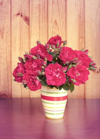 beautiful bouquet of flowers in a vase on wooden tableの写真素材