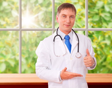Doctor holding an empty hand showing thumbs up. Concept of medicine, health care, diagnostics.の写真素材