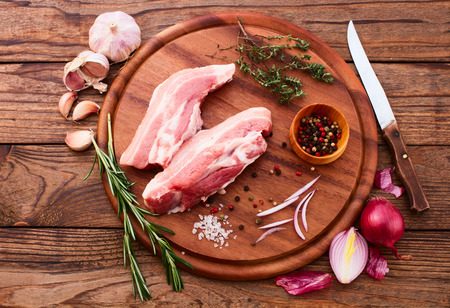 Food. Sliced ââpieces of raw meat for barbecue with fresh vegetables and mushrooms on wooden surface. Meat raw steak. Beef steak bbq. Tomatoes, peppers, spices for cooking meat.の写真素材