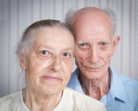 Closeup portrait of smiling elderly couple. Old people holding hands. Concept of marital fidelity, providing for old age, reliabilityの写真素材