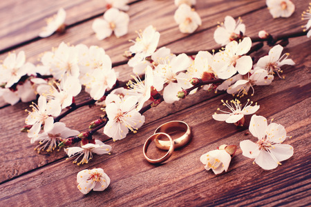 Bridal bouquet of white flowers on wooden surface  Wedding day, unusual designer florist bouquet of delicate roses  Wedding rings の写真素材