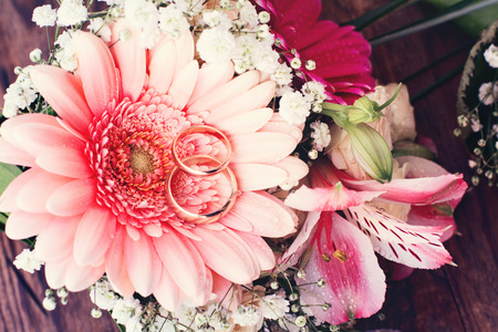 Bridal bouquet of white flowers on wooden surface  Wedding day, unusual designer florist bouquet of delicate roses  Wedding rings の写真素材