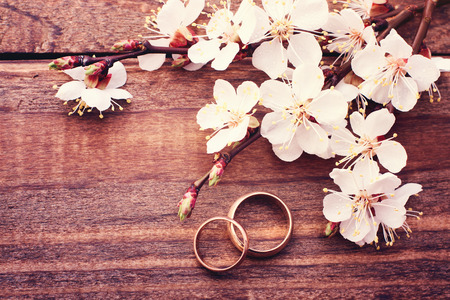 Bridal bouquet of white flowers on wooden surface  Wedding day, unusual designer florist bouquet of delicate roses  Wedding rings の写真素材